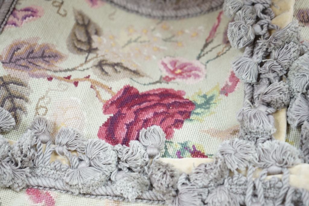 Six small wool worked rectangular cushion covers, designed with roses and trailing flowers on a pale green ground, with mushroom tasselled fringing and velvet backs. 30cm wide x 26cm high. Condition - unused